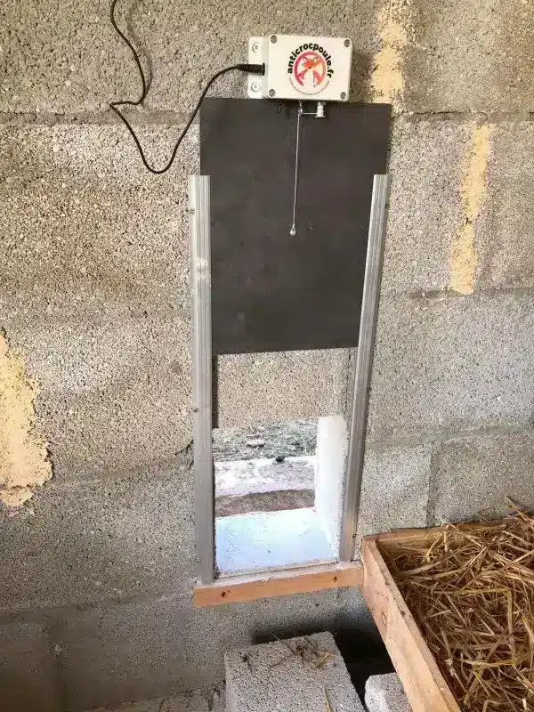 Porte poulailler automatique et solaire la terceira monté à l'intérieur d'un poulailler béton avec cellule solaire déportée.