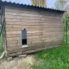 Chalet en bois utilisé comme poulailler avec une porte automatique terceira solaire.