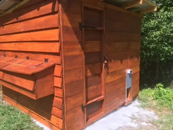 Chalet de jardin en bois servant de poulailler avec une porte solaire guillotine automatique